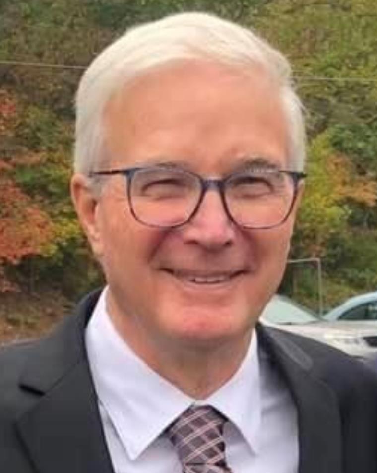 man in suit and glasses smiling at camera