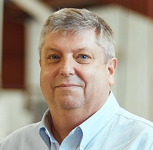 Man in collared shirt smiling at camera